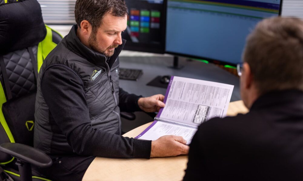 image of Straight-N-Paint vehicle assessor talking to collision repair customer in the office based in Rangiora, North Canterbury