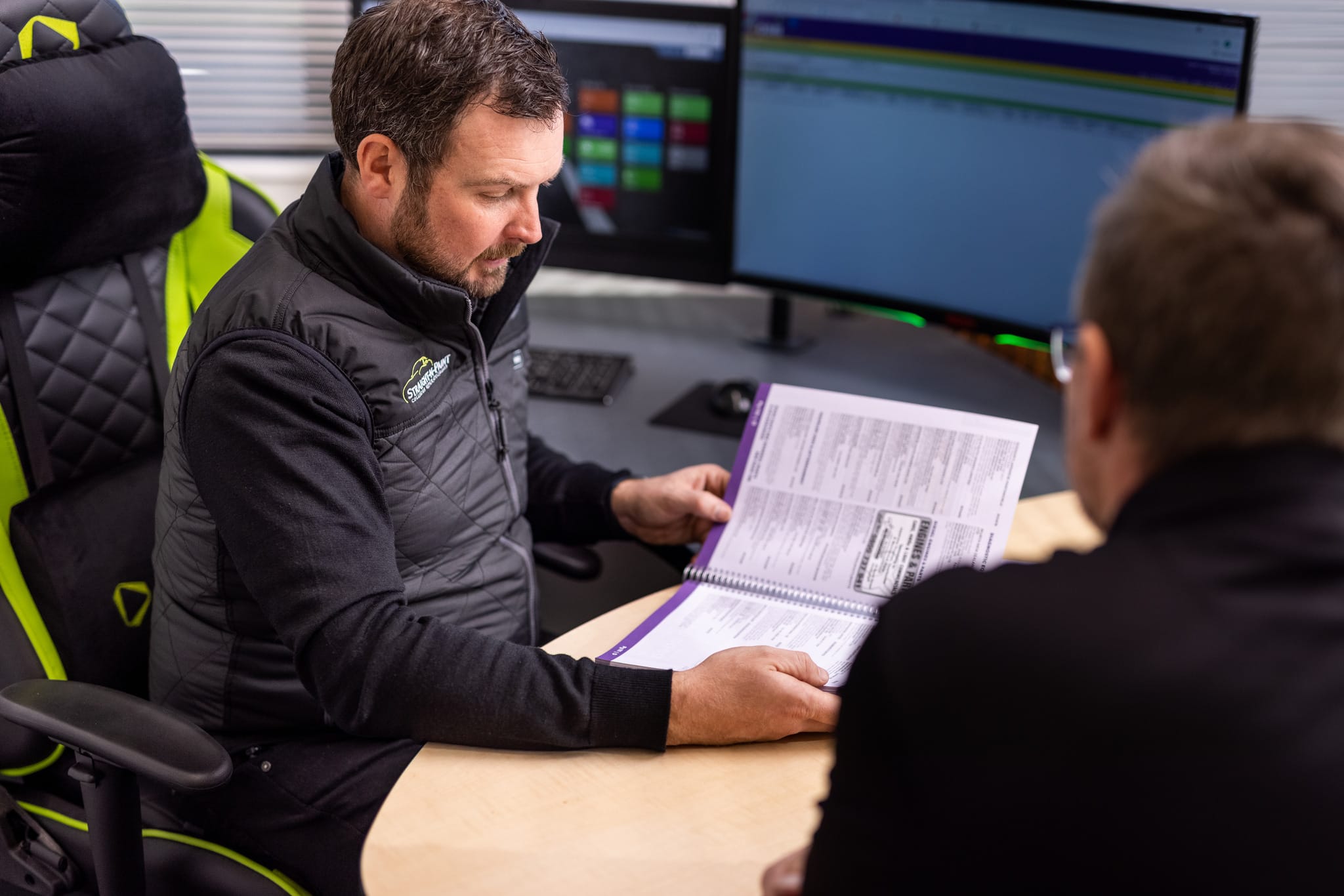 image of Straight-N-Paint vehicle assessor talking to collision repair customer in the office based in Rangiora, North Canterbury