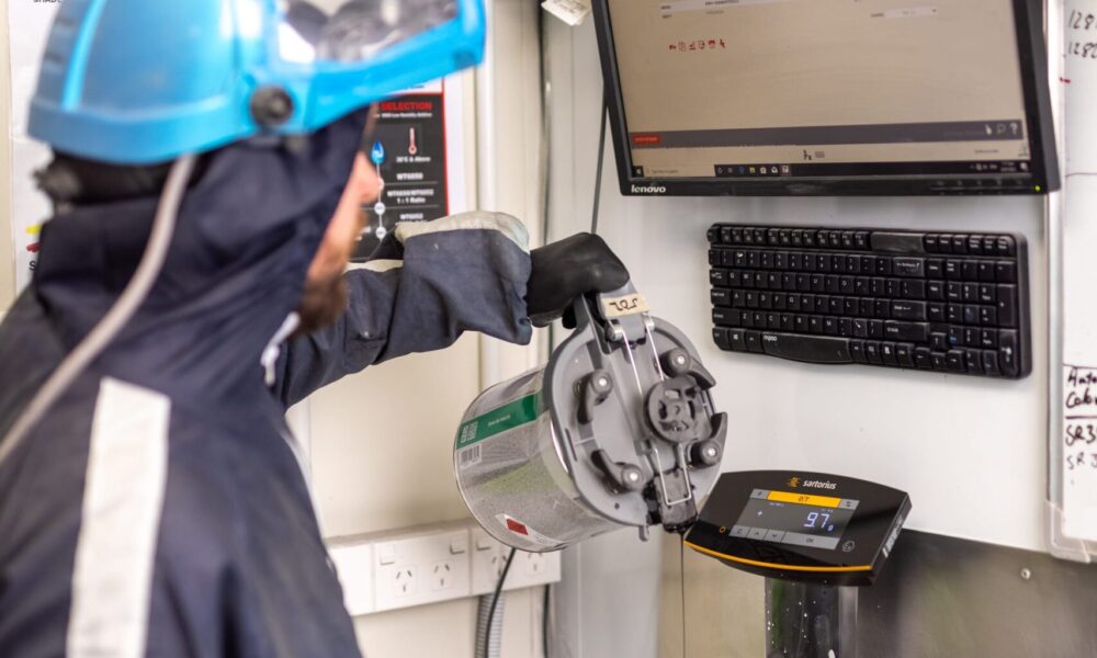 image of Straight-N-Paint employee preparing spray painting equipment in Rangiora collision repair workshop