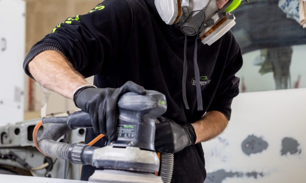 Straight-N-Paint automotive repairer performing panel beating on a vehicle in the Rangiora workshop, Canterbury